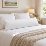 White feather and down bolster pillow on a made double bed in a bright bedroom (AI-generated image)