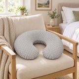 Grey nursing pillow with dimple cover on an armchair in a bright bedroom (AI-generated image)