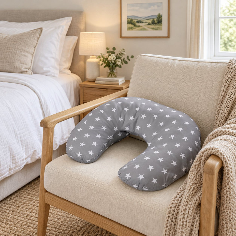 Grey star print nursing pillow on an armchair in a bright bedroom (AI-generated image)