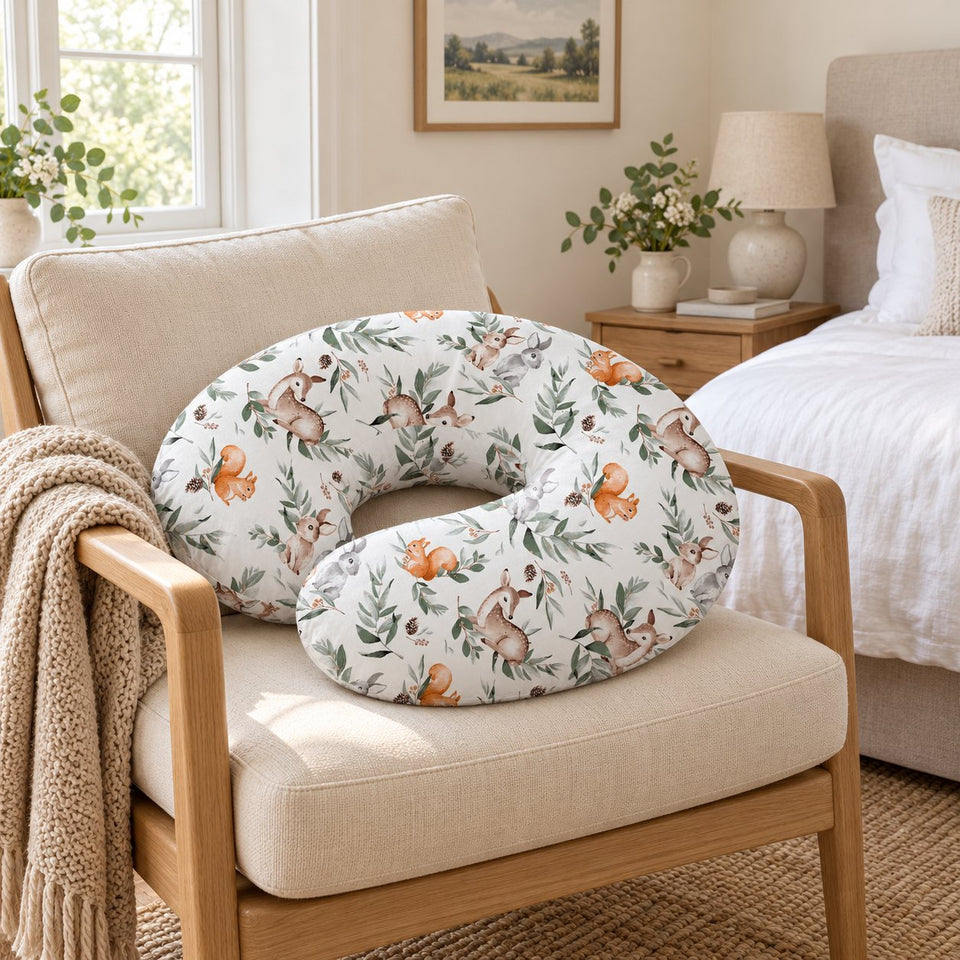 Woodland print nursing pillow on an armchair in a bright bedroom (AI-generated image)