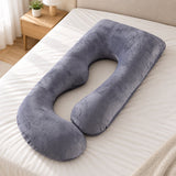 The G Cloud g shaped pregnancy pillow in grey velvet, lying flat on a bed