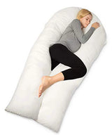 Woman asleep on her side inside a white U shaped pregnancy pillow