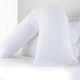 White V shaped pregnancy pillow on a bed